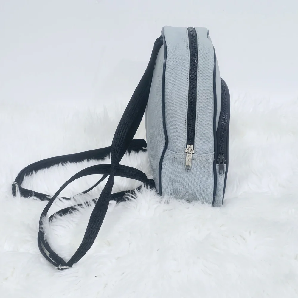 Lacoste mini backpack in a soft light blue shade with navy blue trim accents.